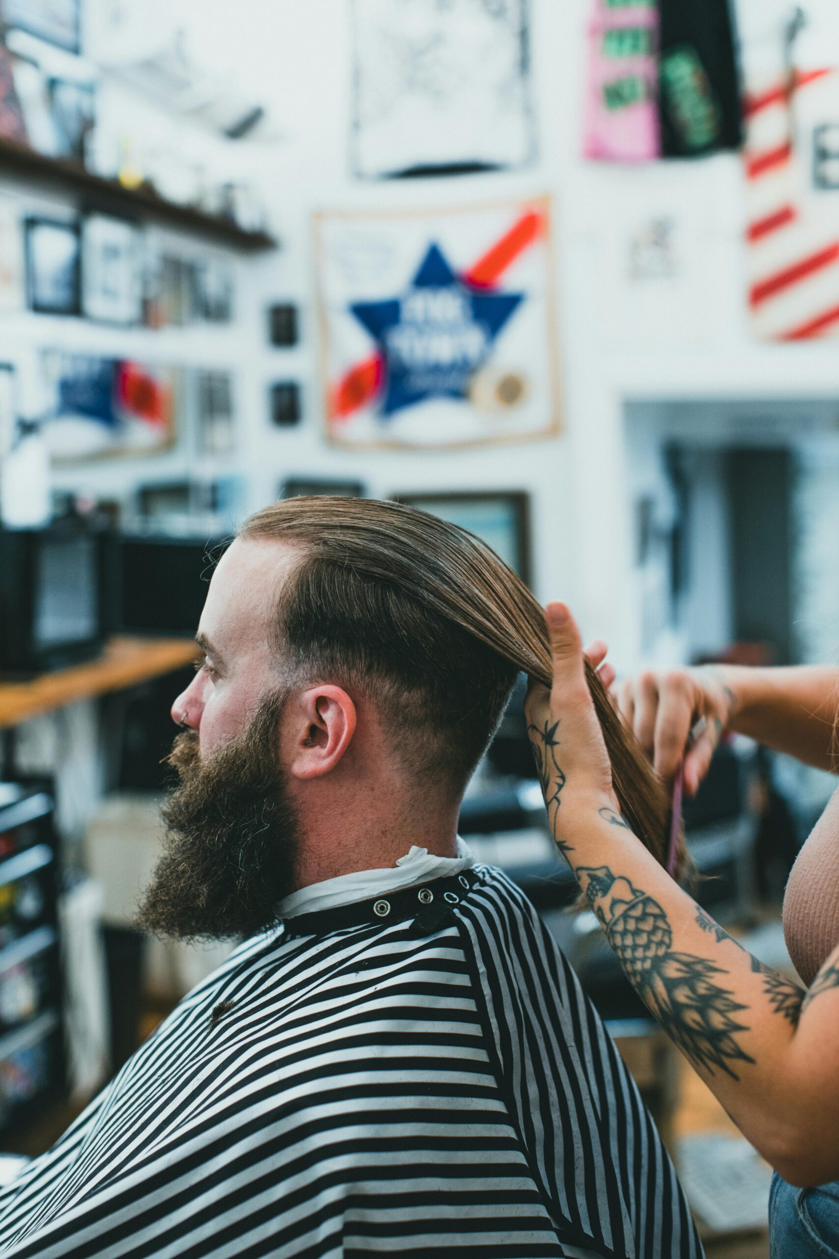 A barber skillfully trimming a man's beard and combing hair in a stylish salon setting.